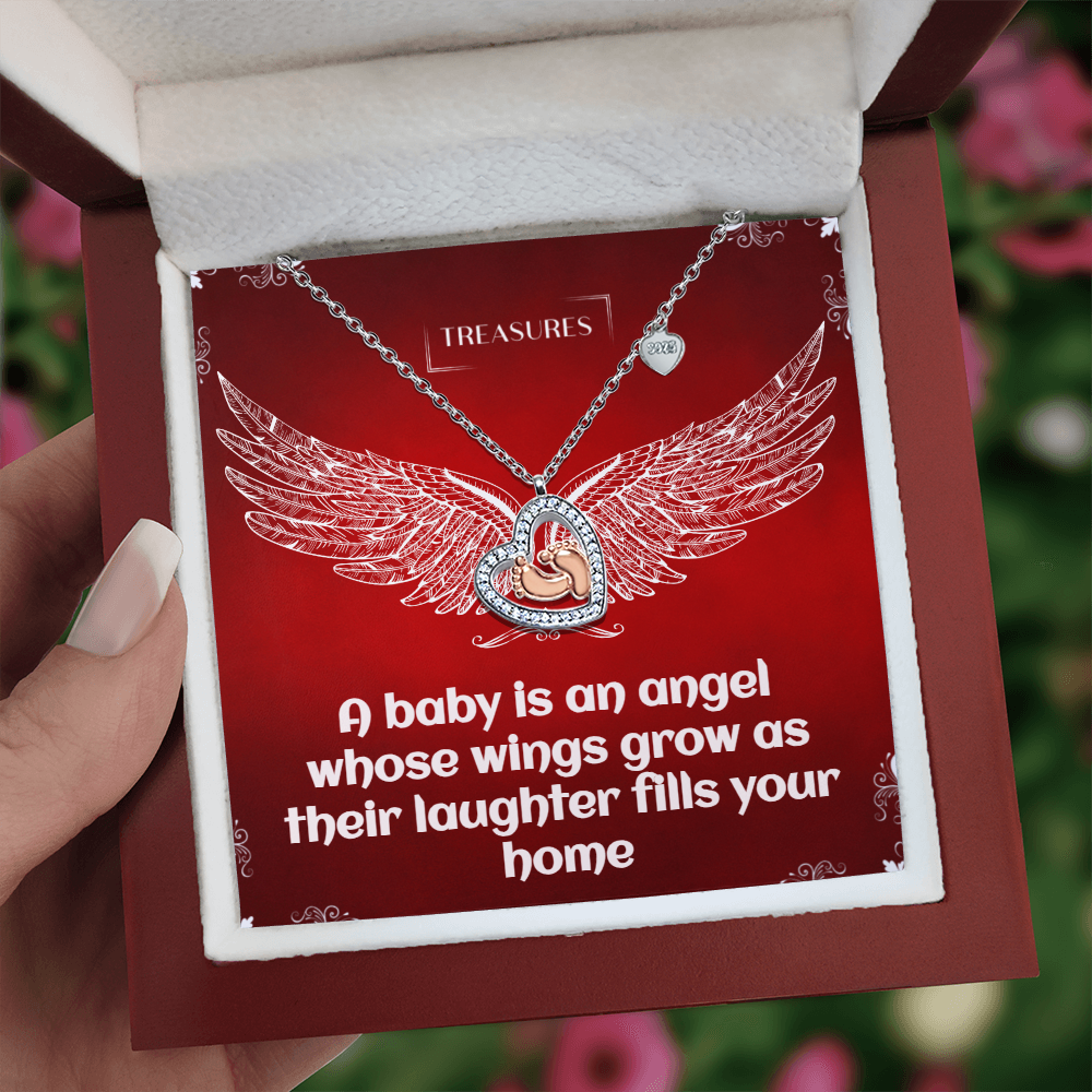 Heart-shaped necklace with sparkling cubic zirconia and delicate rose gold baby feet, symbolizing love, family, and new beginnings.
