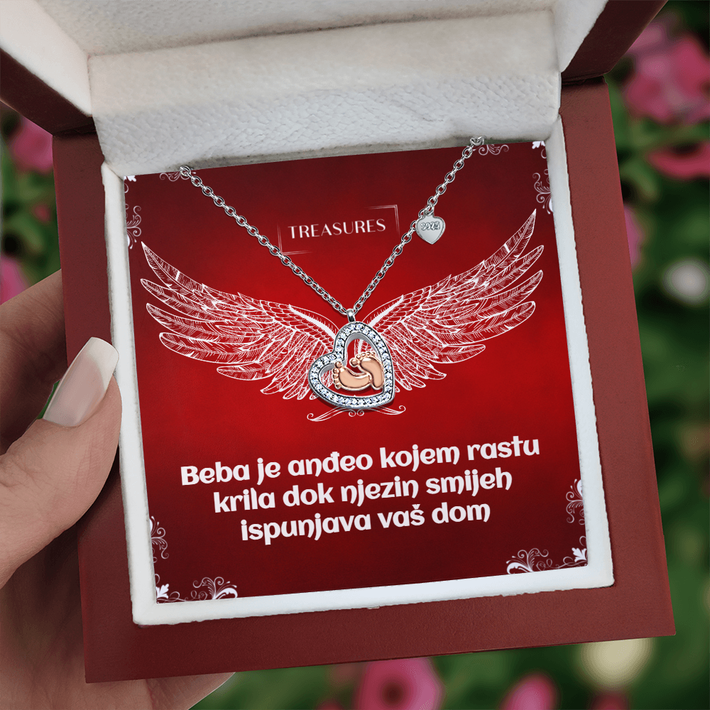 Ogrlica u obliku srca s blistavim kubičnim cirkonima i nježnim bebinim stopalima u ružičastom zlatu – simbol ljubavi, obitelji i novih početaka.
