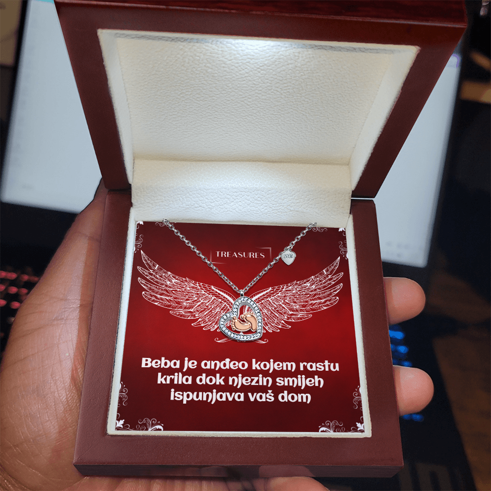 Ogrlica u obliku srca s blistavim kubičnim cirkonima i nježnim bebinim stopalima u ružičastom zlatu – simbol ljubavi, obitelji i novih početaka.
